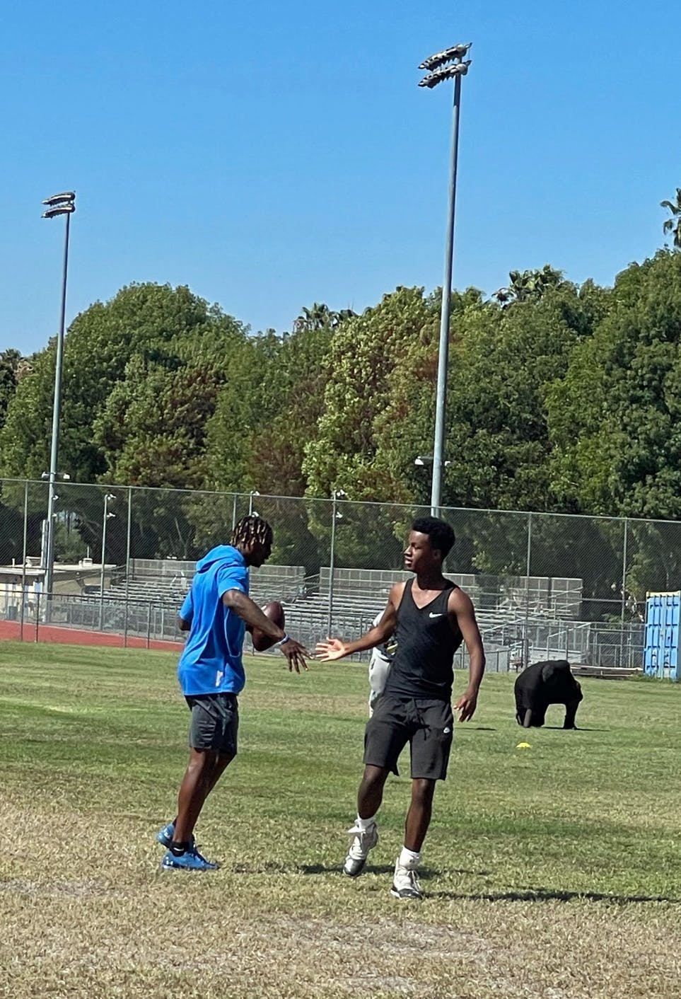UCLA Football player Morrell Osling with a student athlete at Crenshaw High School. 