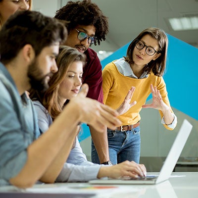 People working in an office looking at a laptop