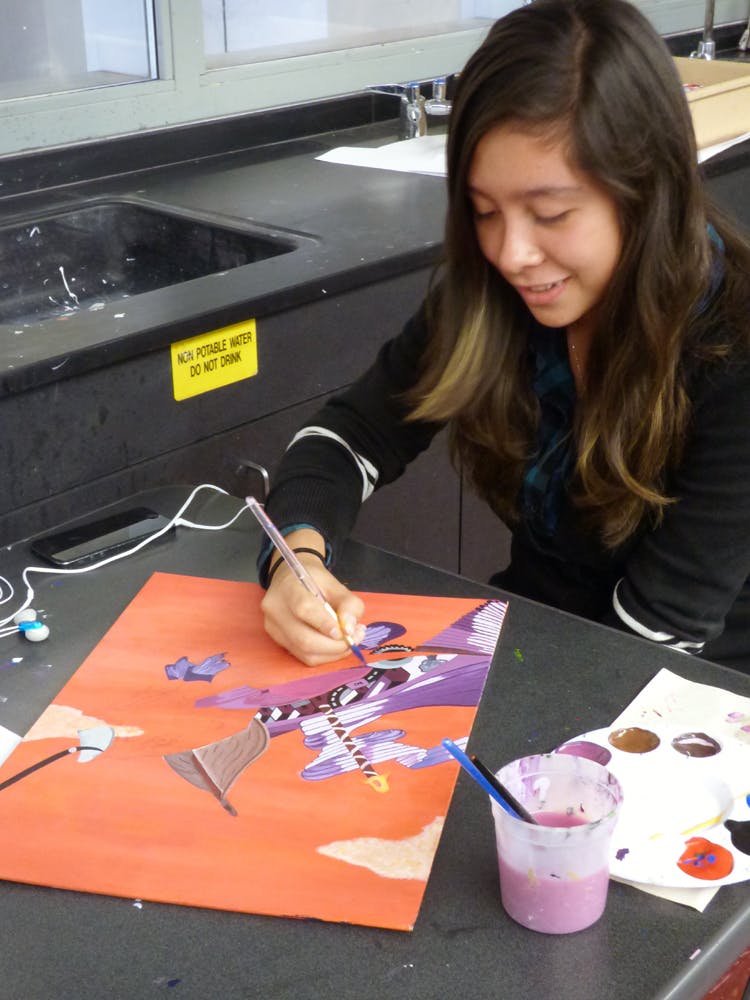 Leslie Roman, a student in Grace Maddox's art class, works on a painting for the 3rd Annual UCLA Community School Art Auction. Photo by Grace Maddox