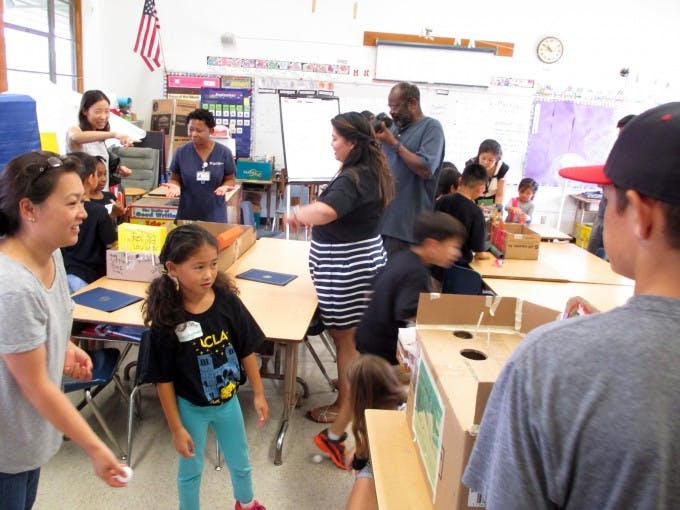 Ada Hasegawa (at far left) tries out a game built by her daughter Ashley and other participants in a STEM workshop as part of the UCLA Young Scholars Program. 