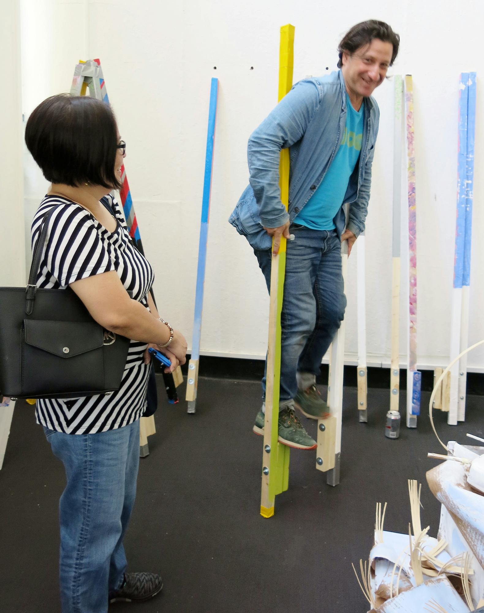 Recent UCLA MFA graduate Luis Tentindo shows a FORM Academy parent the results of the &quot;Walking Taller&quot; project.