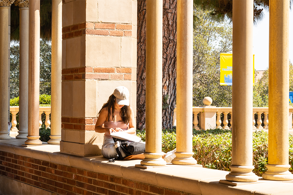 Student on Royce Hall wall