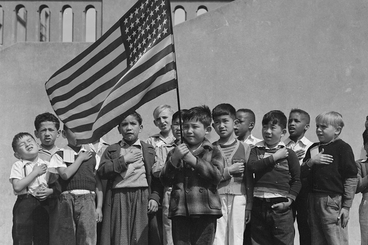 boys pictured here, pledging allegiance to the flag at a California public school. In World War II, children in families of Japanese ancestry were evacuated with their parents and housed in War Relocation Authority centers.