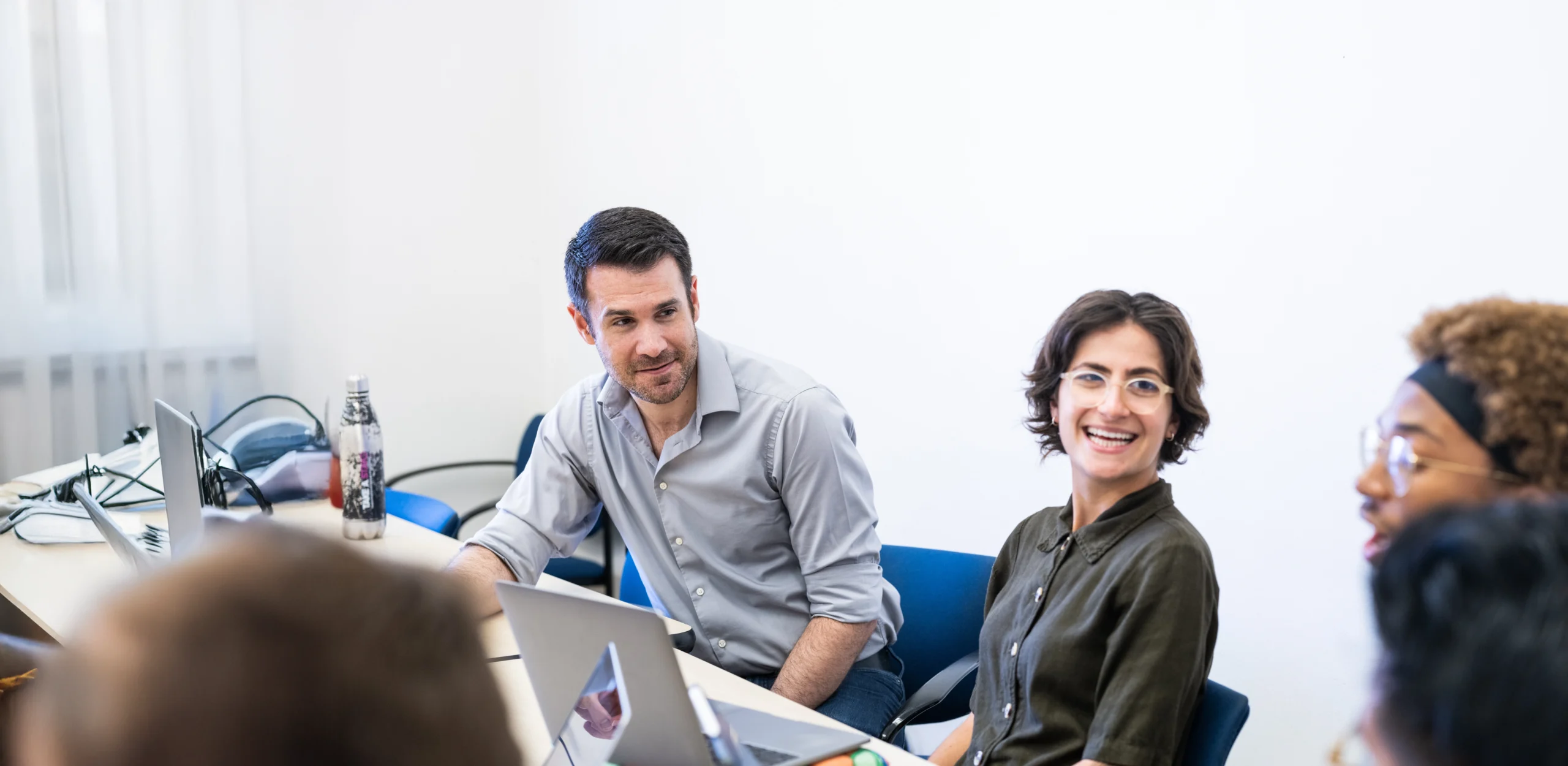 Professor in conversation with students in classroom.
